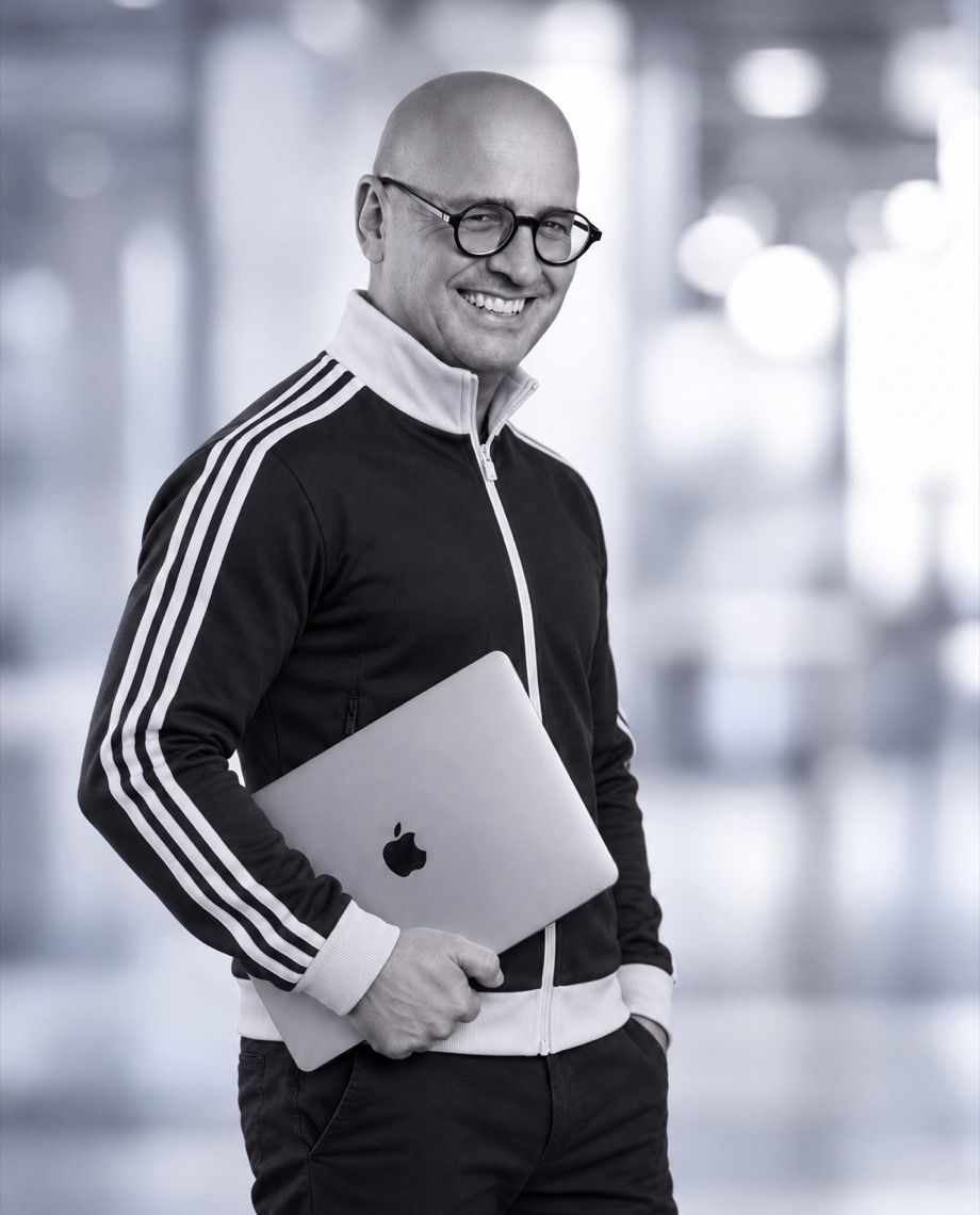 Sascha Herbst, lachend, mit Laptop unter dem Arm